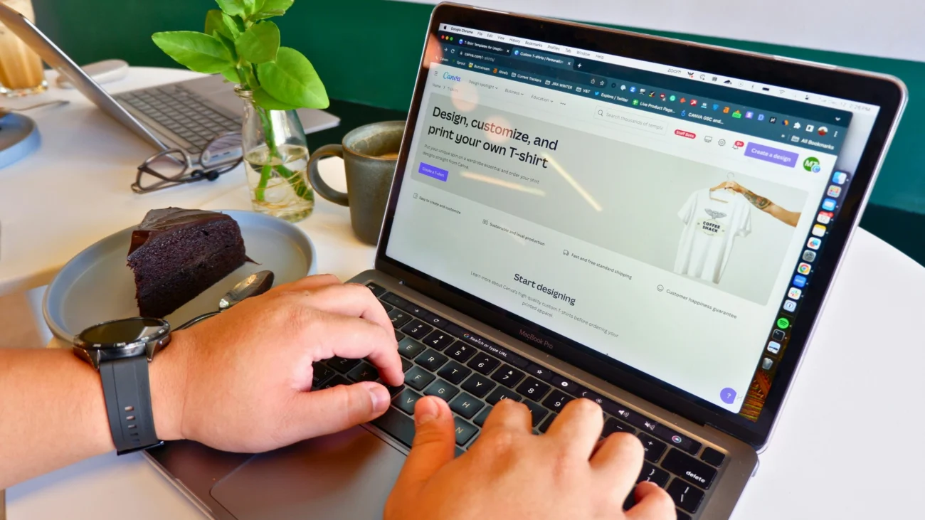 How to make money selling digital products using Canva — person designing custom t-shirt templates on MacBook laptop in 2026