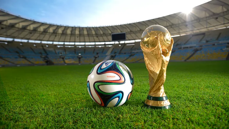 How to watch FIFA World Cup 2026 free — FIFA World Cup trophy and match ball on stadium grass with legal streaming options